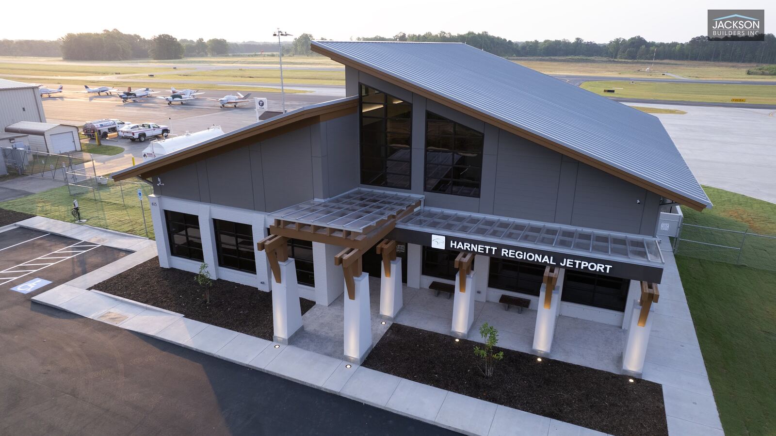 The Harnett Regional Jetport terminal from the road, its tall sloped roof and covered entrance under an evening sky