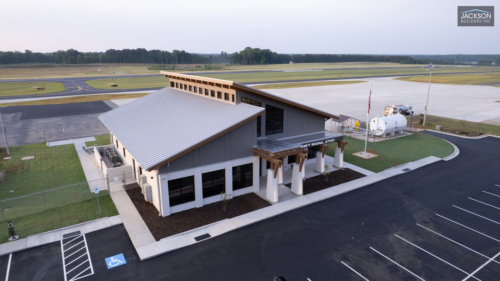 The terminal's road-facing entrance and parking lot, with the runway stretching out behind