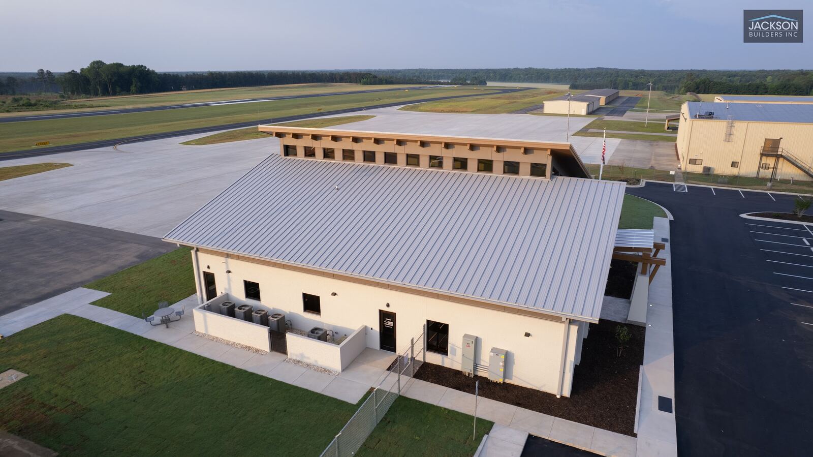 An aerial view along the terminal's metal roof to the clerestory skylights and the airfield beyond